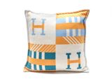 un oreiller blanc orné de carrés bleus et orange