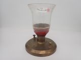 un petit vase en verre contenant une substance rouge