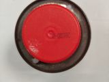 a close up of a red button on a white surface