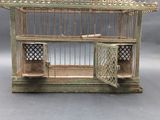 a small bird cage with a door open on a table