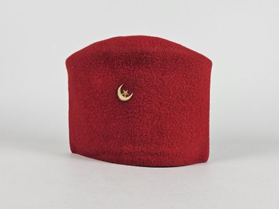 une image représentant un chapeau rouge orné d'un croissant doré
