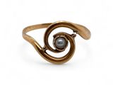 a close up of a gold ring with a pearl in it