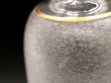 a glass vase with a gold rim sitting on a table