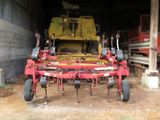 a tractor that is parked in a barn with a tractor behind it