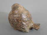 a small figurine of a bird sitting on a table