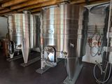 several stainless steel tanks are lined up in a row in a room