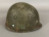 an old helmet is sitting on a table with a white background