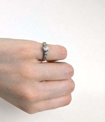 la main d'une femme tenant une bague sertie d'un diamant