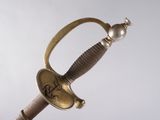 a gold sword with a pearl on the handle