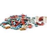 a pile of toy cars next to a roll of toilet paper
