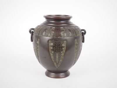 un vase marron orné de motifs verts sur un fond blanc