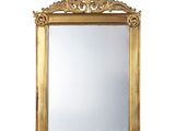 une image d'un miroir encadré d'or sur un mur blanc
