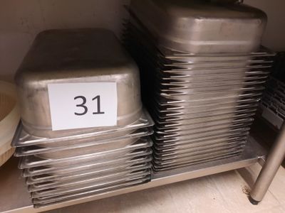 Plusieurs plateaux de nourriture sont empilés sur une étagère dans une cuisine