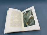 un livre ouvert sur lequel figure l'image d'une femme assise sur une chaise