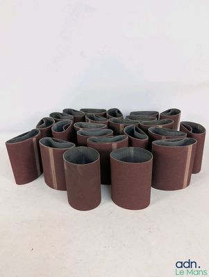 un gros plan sur un ensemble de ceintures marron posées sur une surface blanche