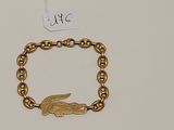 un gros plan d'un bracelet en or orné d'un alligator