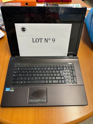 un ordinateur portable posé sur une table sur laquelle figure le chiffre « 9 »