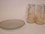 deux verres et une assiette posés sur une table à côté d'une pièce de monnaie