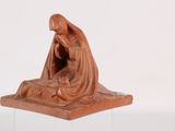 figurine of a woman kneeling on a rock with a baby jesus in her lap