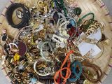 a basket full of assorted jewelry on a table
