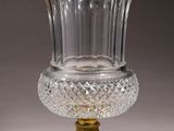 a glass vase with a gold rim on a stand