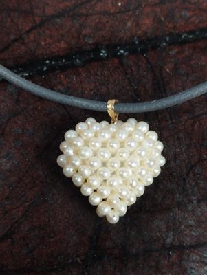 Pendentif coeur constitué d'une résille de petites perles, l…