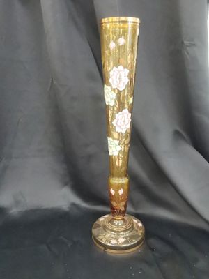 un vase doré orné de fleurs sur fond noir