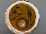 a glass vase with a ball in it on a table