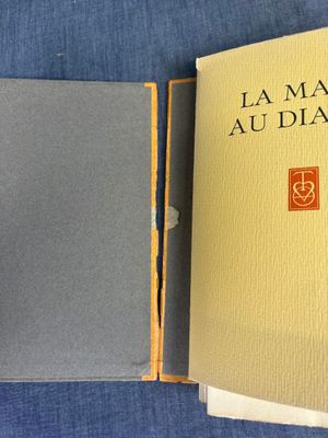 un livre ouvert posé sur une table recouverte d'un tissu bleu