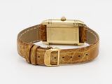 an image of a wrist watch with a gold case and brown leather strap