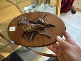 une personne tenant une plaque en bois sur laquelle figure un chien