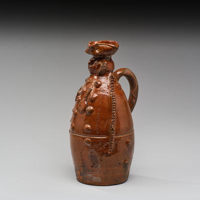 une image représentant un vase marron muni d'une anse, posé sur une surface grise
