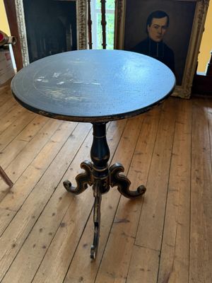une petite table sur laquelle est posé un tableau, dans un coin de la pièce