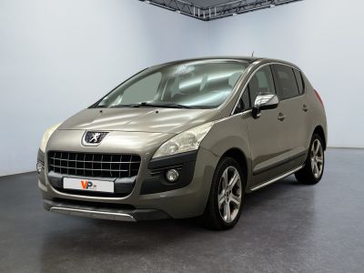 La voiture argentée est garée dans une grande pièce au sol noir.