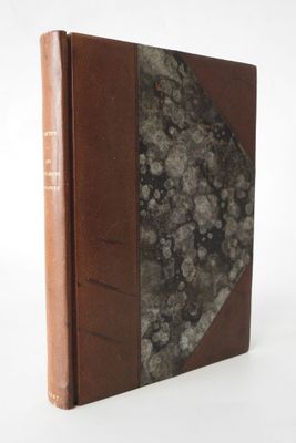 an old book with a brown cover sitting on top of a white table