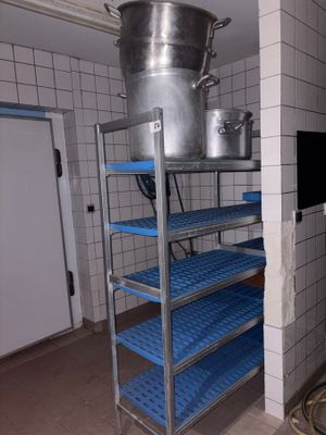 shelves with pots and pans on top of them in a kitchen