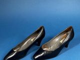 pair of black leather shoes on a blue background