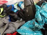 a pile of clothes and a cell phone on a bed