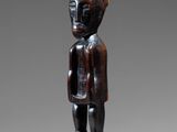 a wooden statue of a man standing on a pedestal