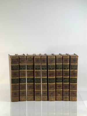 six vieux livres empilés les uns sur les autres sur une surface blanche