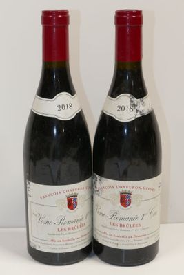 deux bouteilles de vin rouge posées sur une table blanche