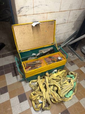 une caisse remplie de bananes posée par terre à côté d'une grappe de bananes