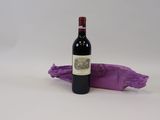 une bouteille de vin posée à côté d'un sac violet
