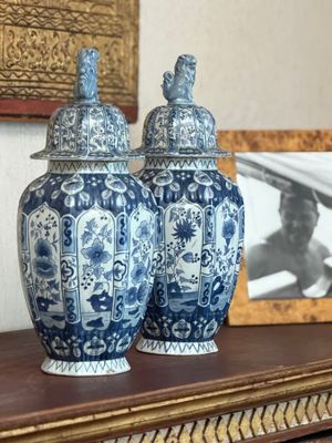 two blue and white vases sitting on a table