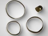 three rings and a ring with a gold ring on a white surface
