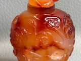 un vase en verre orange orné d'un oiseau