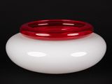 un vase blanc avec un couvercle rouge sur fond noir