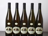 six bottles of wine are lined up on a wooden table