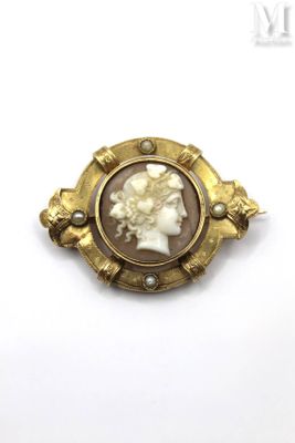 a close up of a gold broochle with a woman ' s face