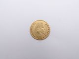 a gold coin on a white surface